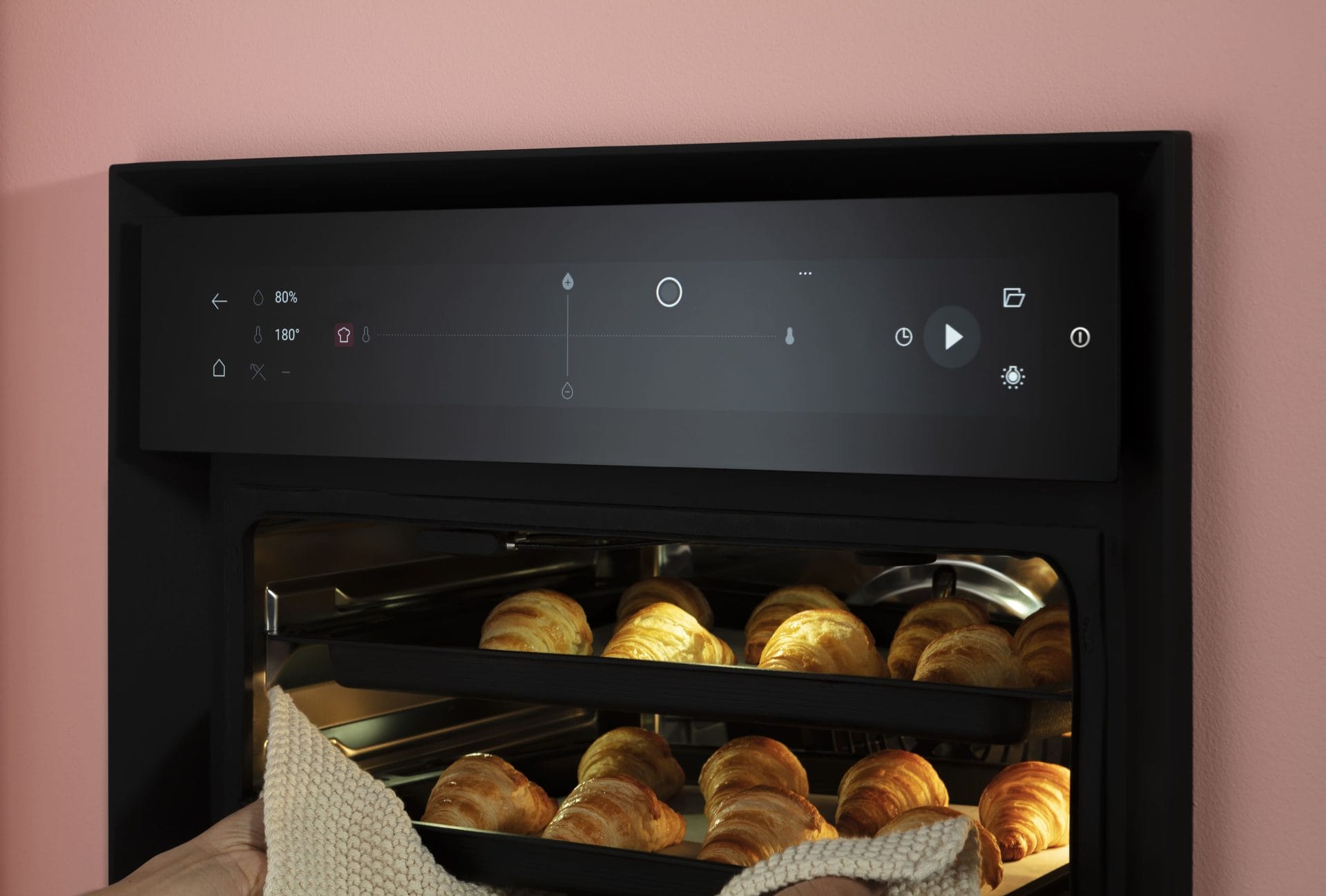 Built-in smart oven baking croissants with touchscreen controls