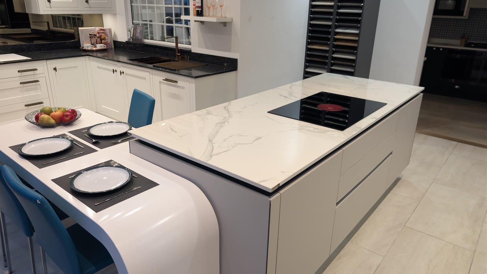 Modern kitchen island with induction hob, white worktop and integrated seating